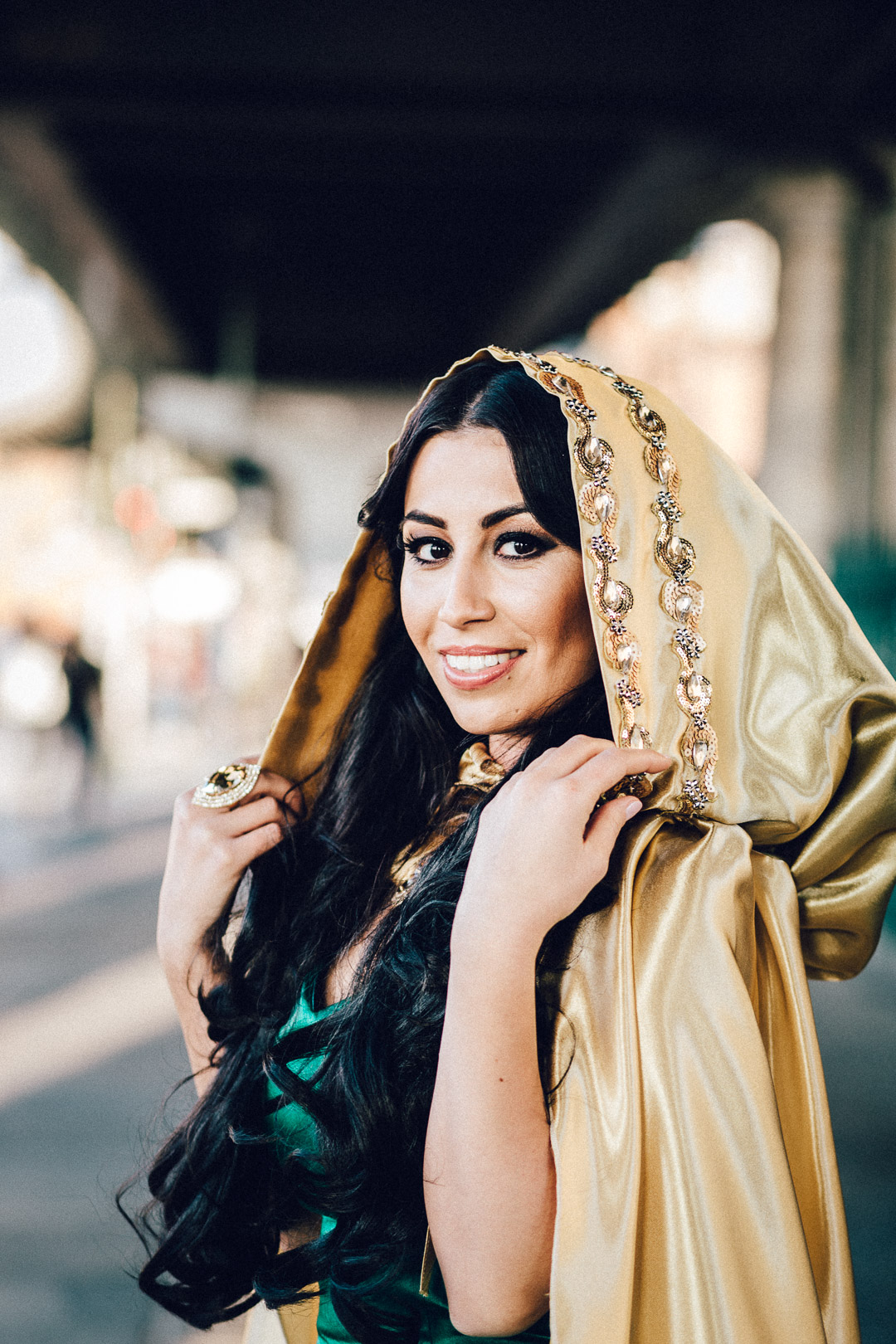 Frau in goldenem cape schaut in Kamera